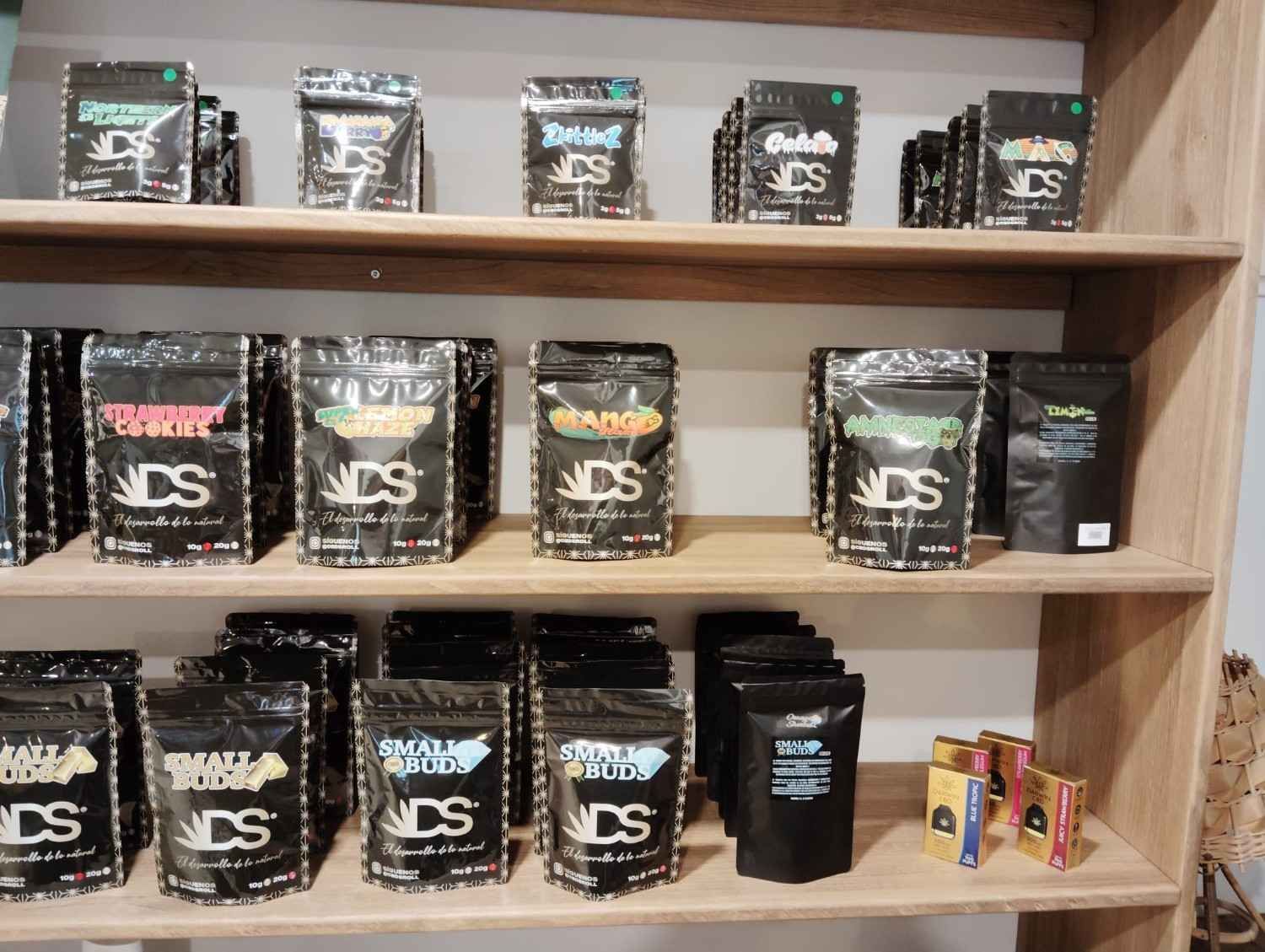 Un estante de madera repleto de diversos productos de cannabis o hierbas envasados ​​y etiquetados como 