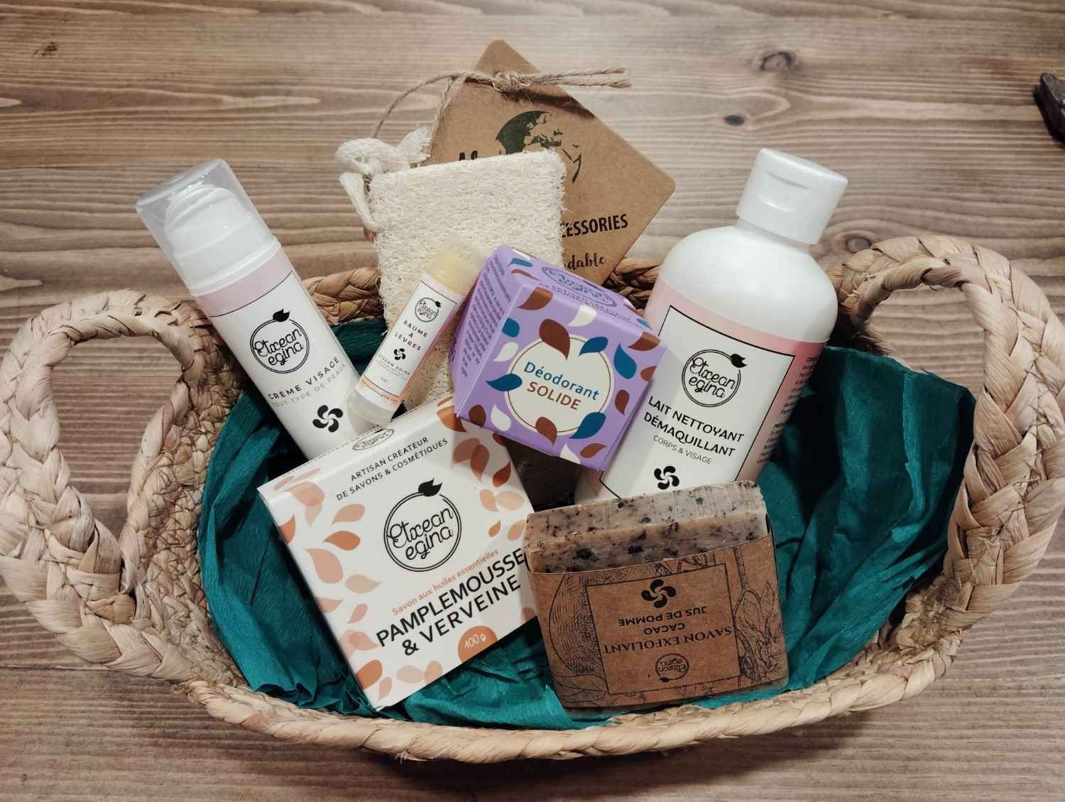 Una cesta de regalo repleta de productos variados para el cuidado de la piel y el baño, que incluye jabón, loción y una esponja, sobre una superficie de madera.