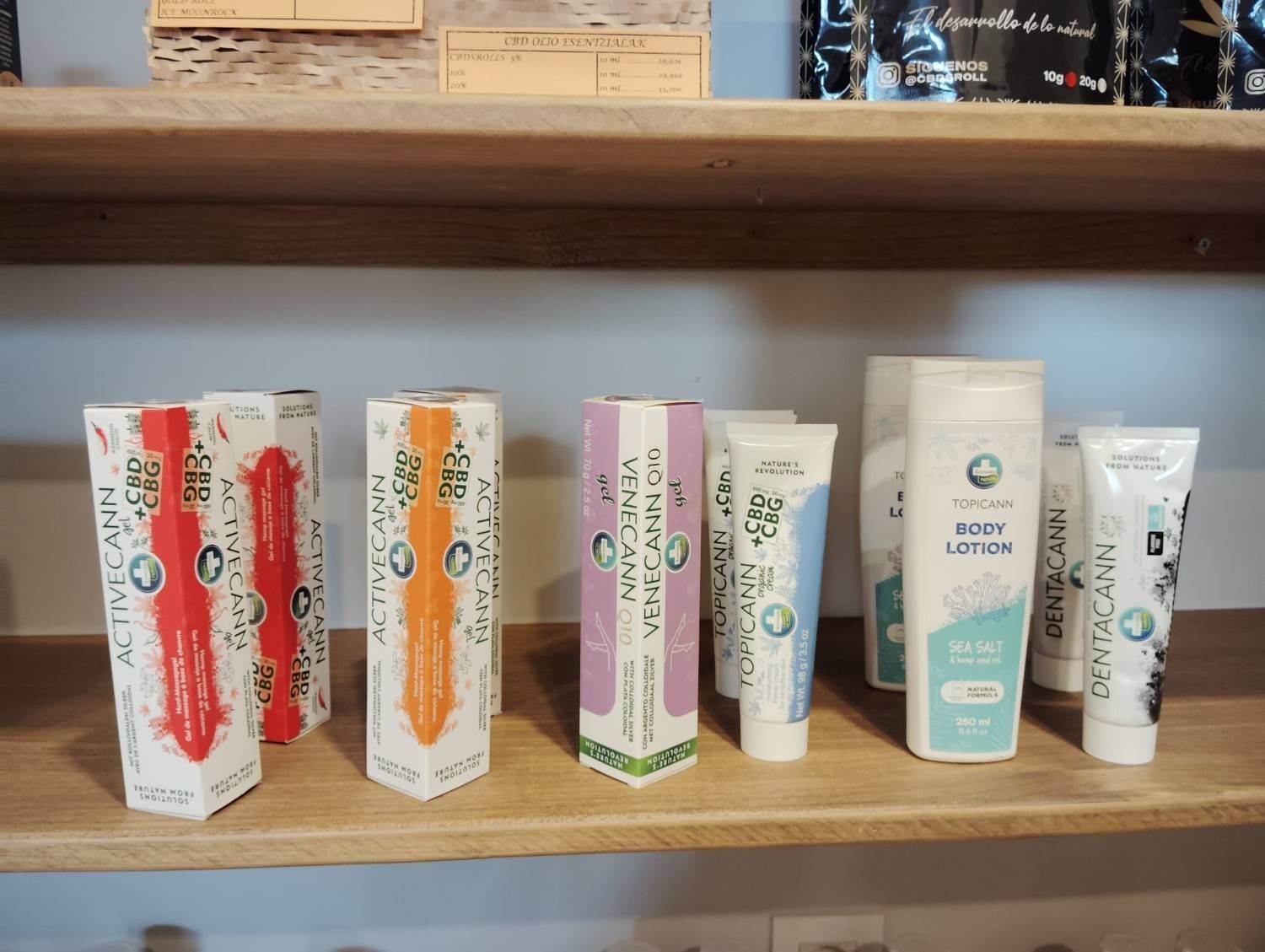 Estantería con diversos frascos y tubos de productos para el cuidado de la piel, incluyendo artículos con etiquetas naranjas, rojas y azules.