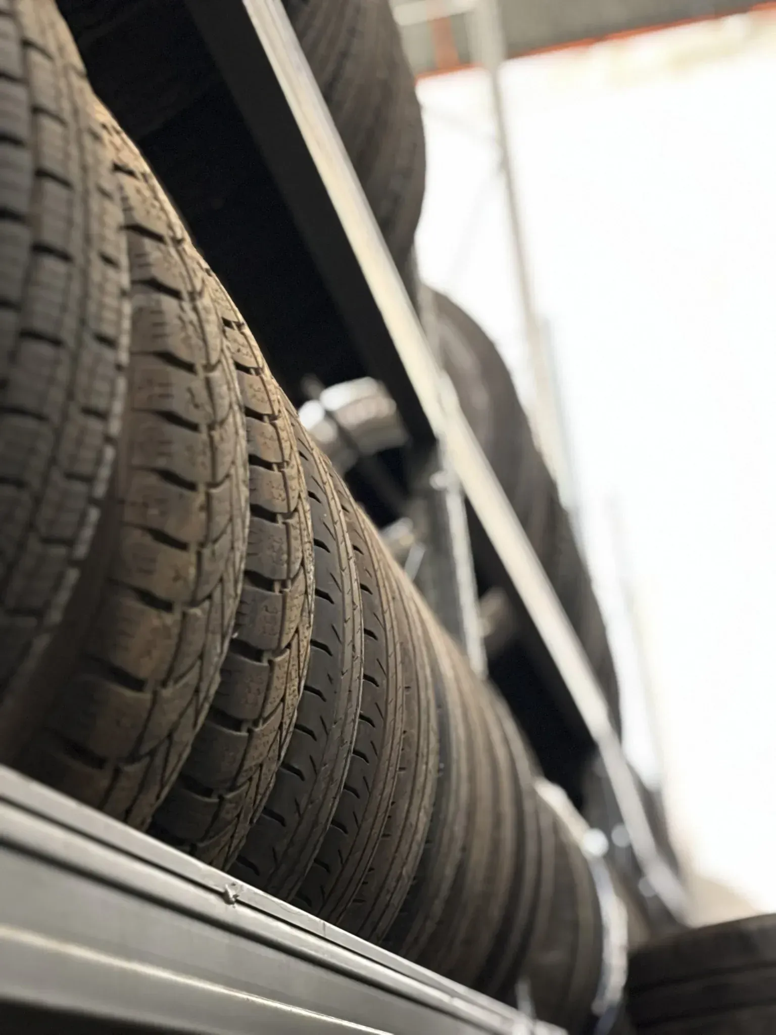 Neumáticos apilados en estantes en un almacén.