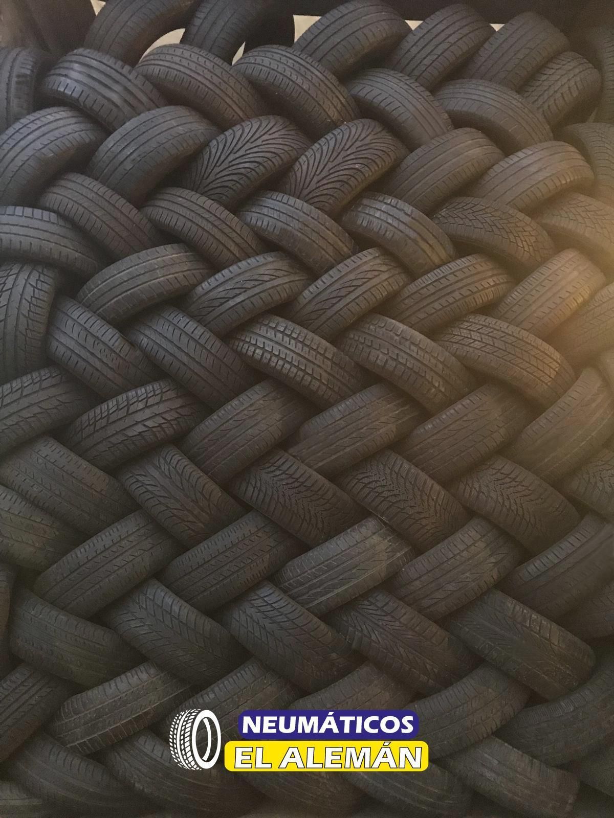 Neumáticos dispuestos en un patrón tejido, posiblemente un display, con el logo 