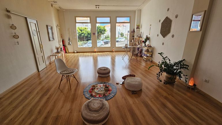 Habitación espaciosa con suelo de madera, grandes ventanales y cojines decorativos. La luz natural inunda el espacio.