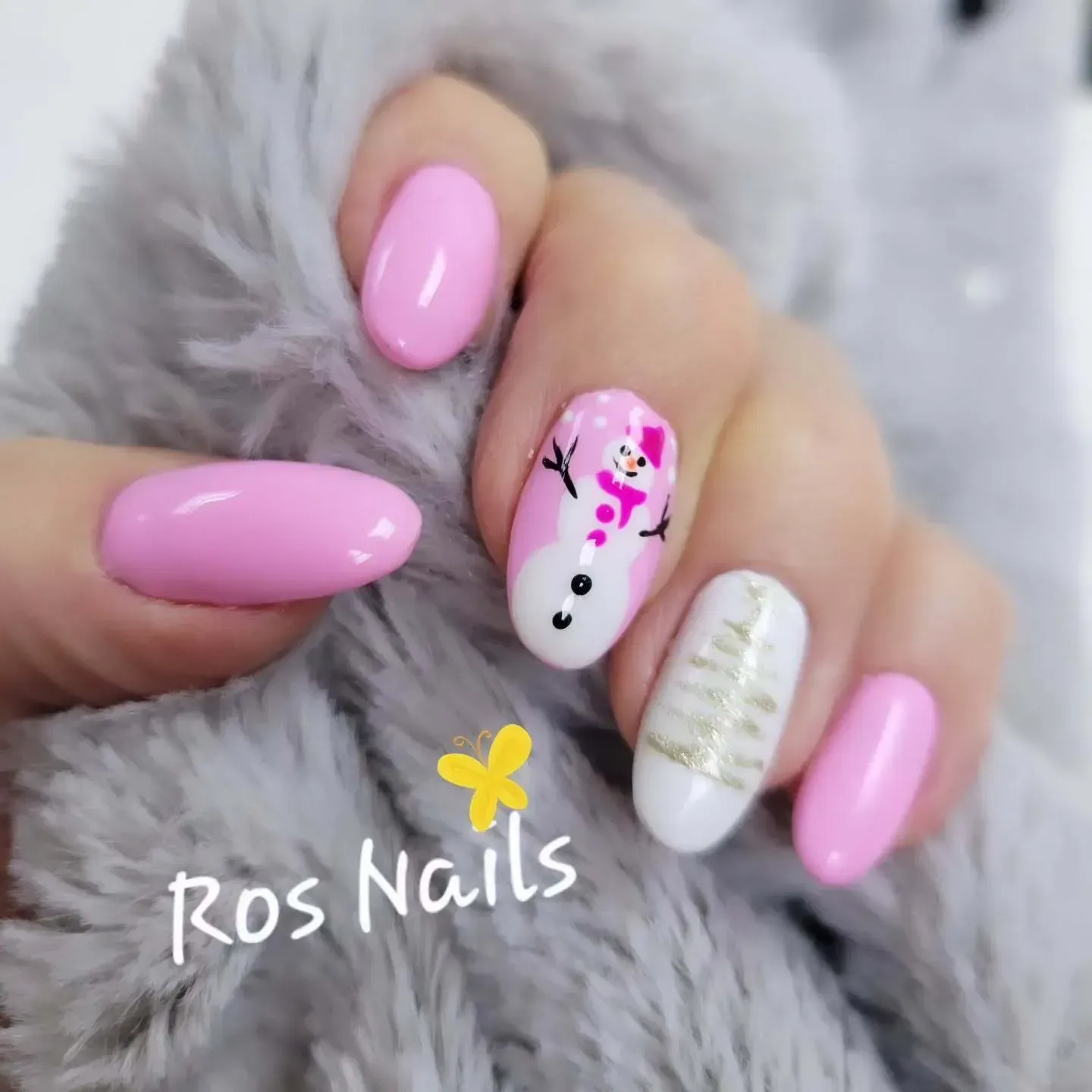 Par de pies con uñas de punta francesa, apoyados sobre una superficie texturizada, con una flor rosa.