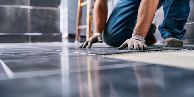 Un carreleur en train de poser du carrelage.