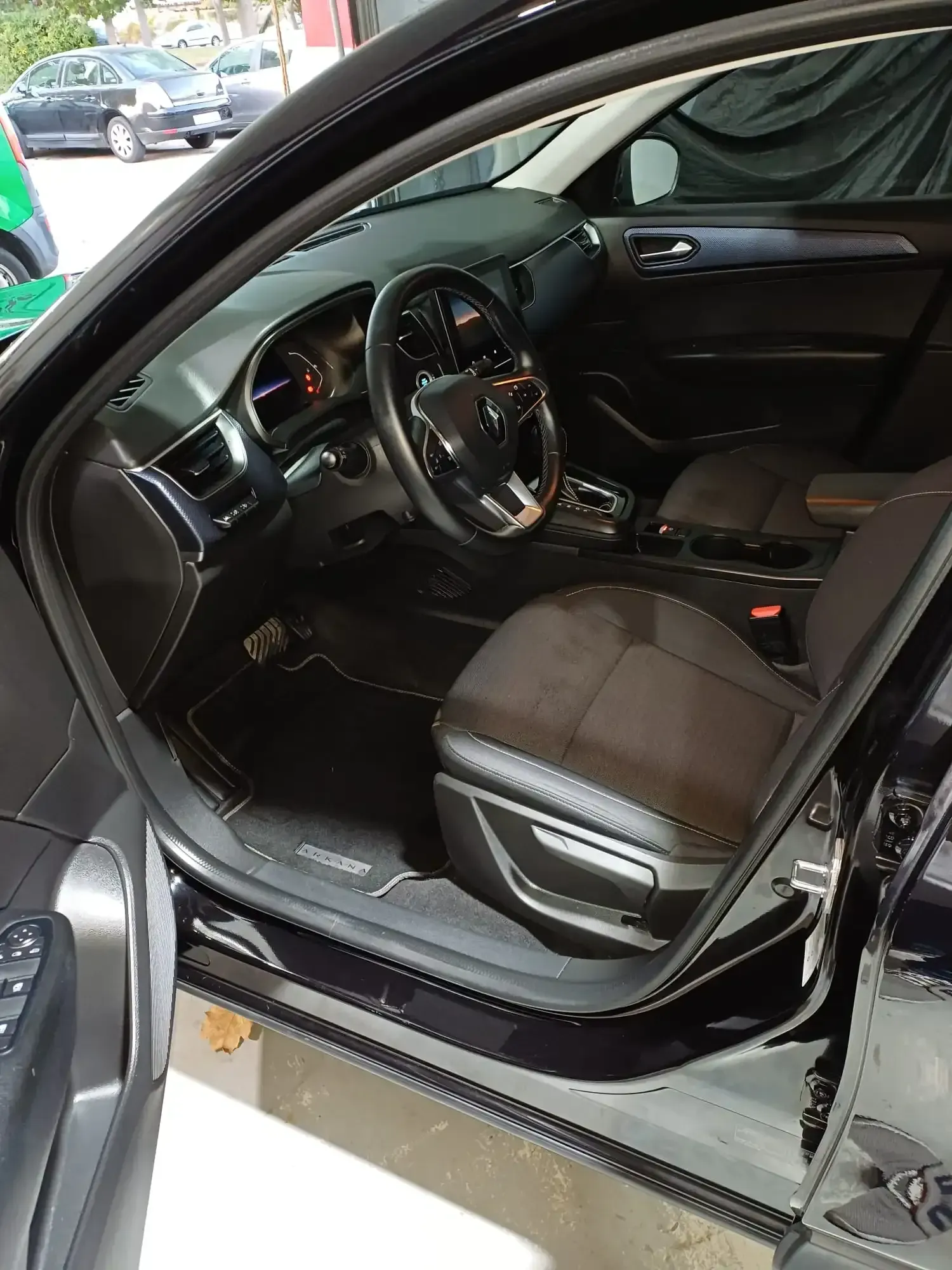 Interior de coche de lujo con asientos de cuero negro y puerta del conductor abierta.