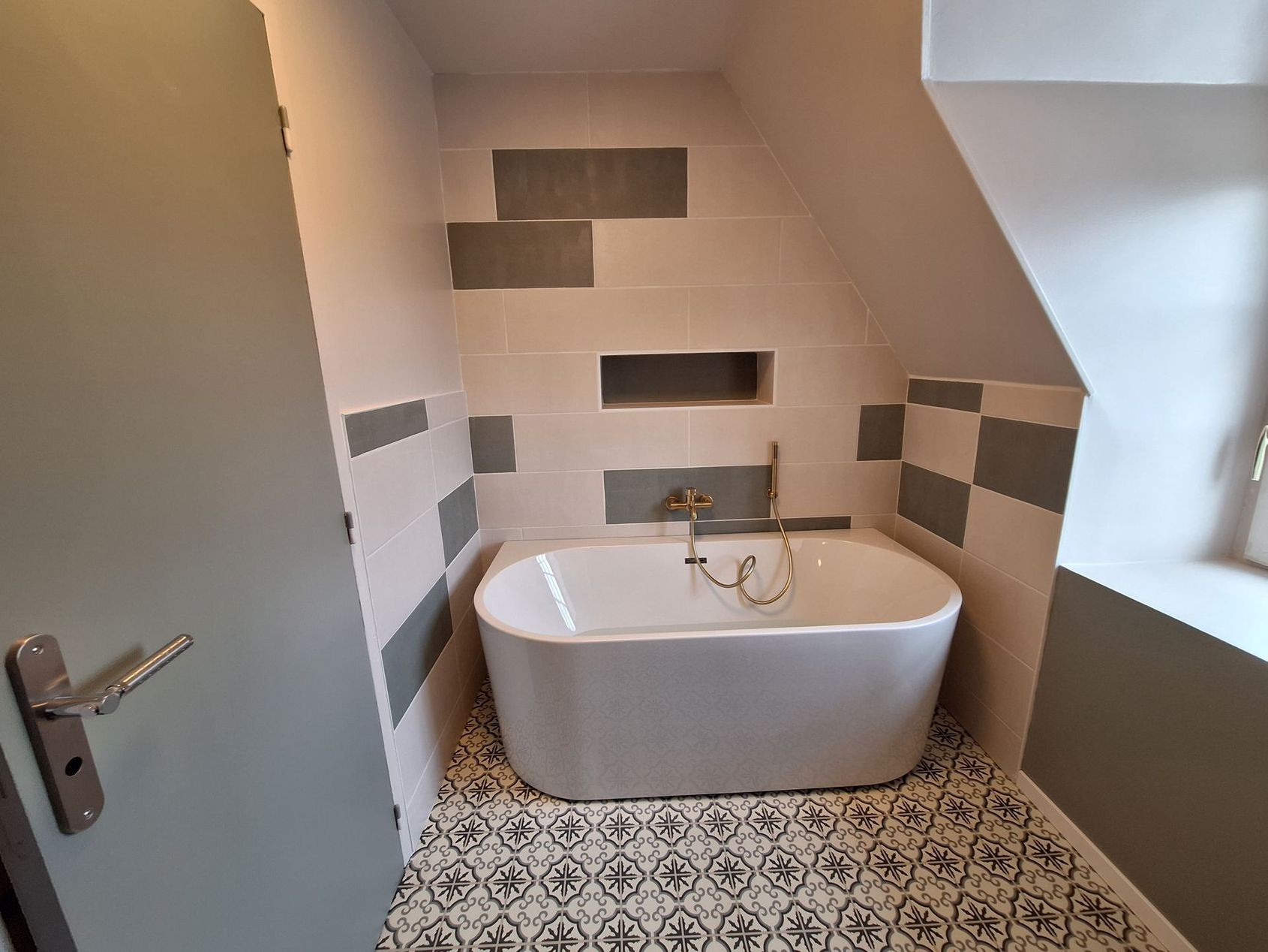 Salle de bains moderne avec baignoire et vasque blanches, tapis noir.