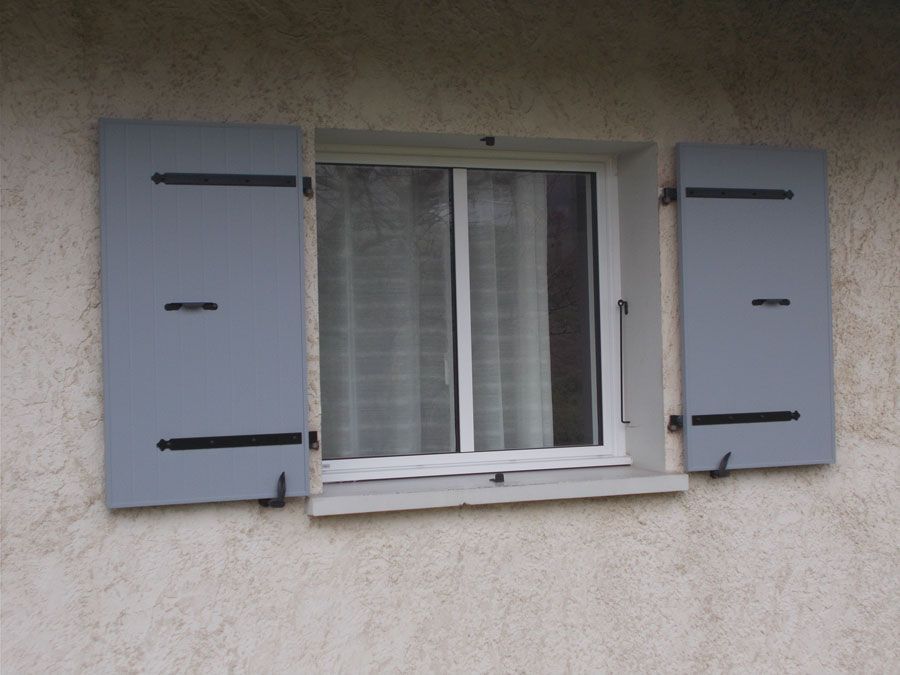 Fenêtre de maison avec volets battants gris