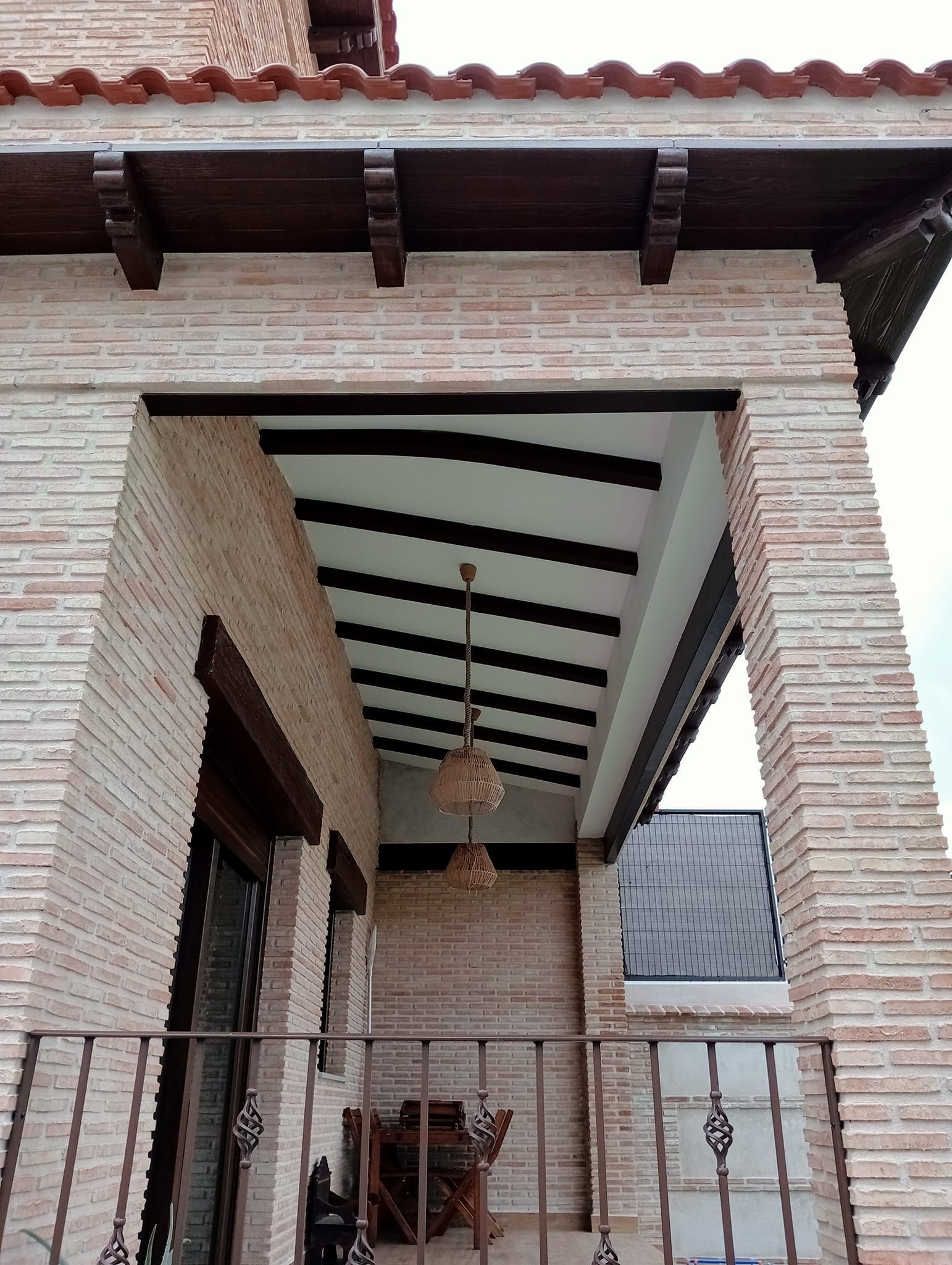 Un edificio de ladrillo con un balcón y una luz de techo.