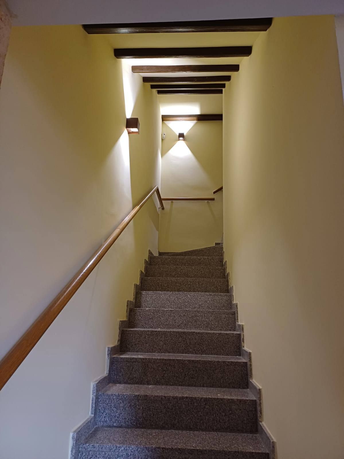 Una escalera con barandilla de madera que conduce al segundo piso.