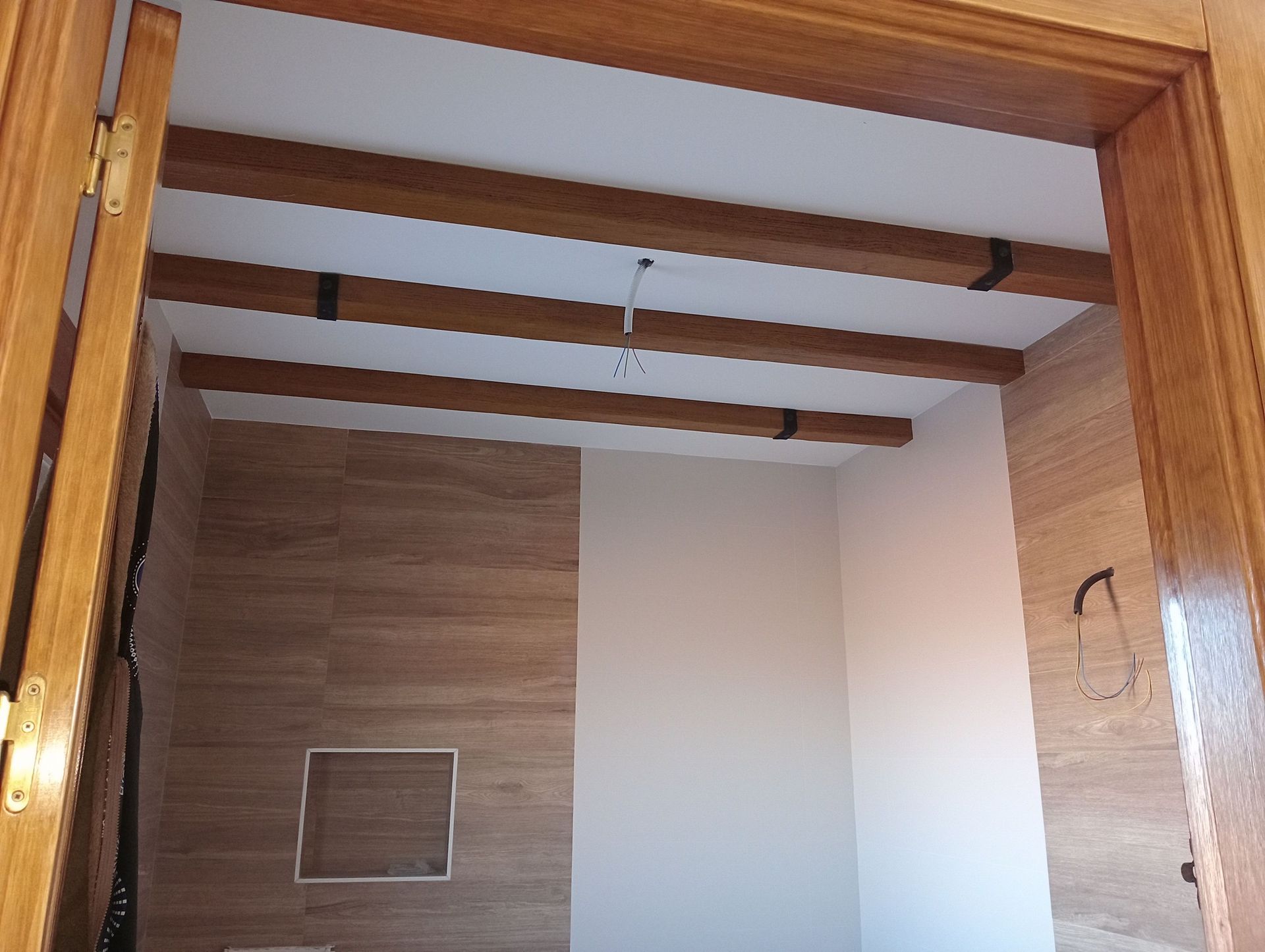 Una habitación vacía con vigas de madera en el techo