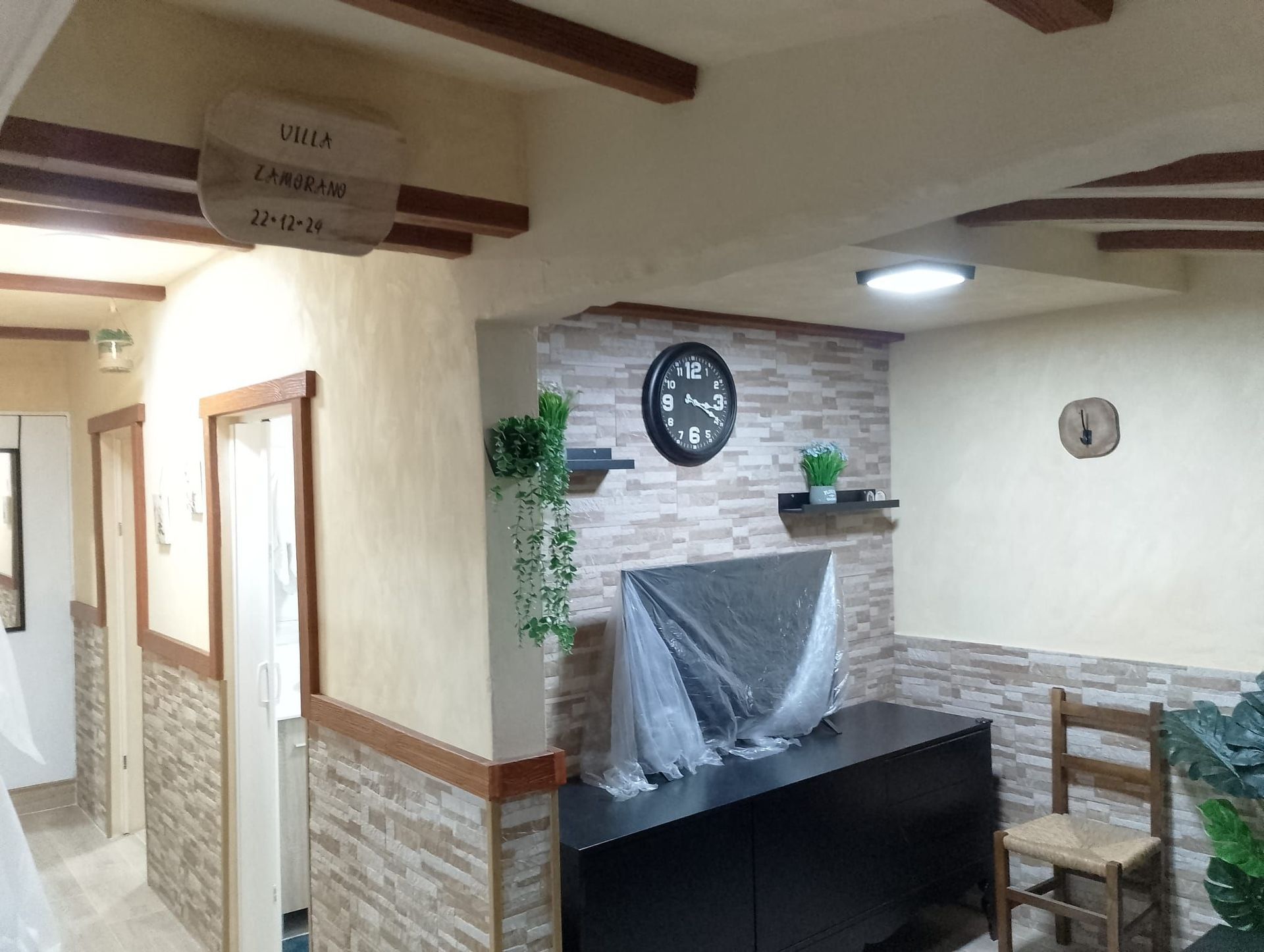 Una habitación con un reloj en la pared y una mesa y sillas.