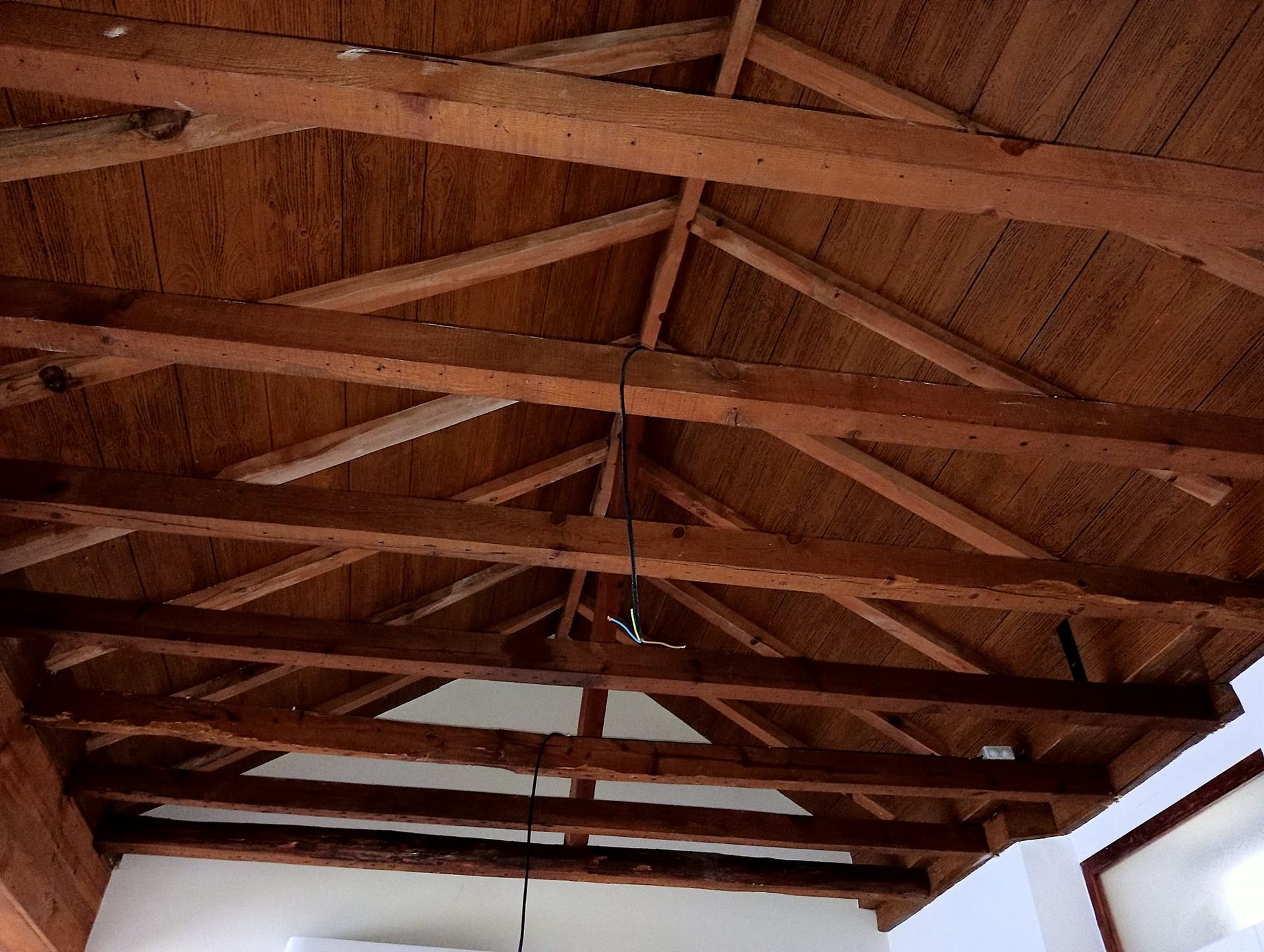 El techo de un edificio está hecho de vigas de madera.