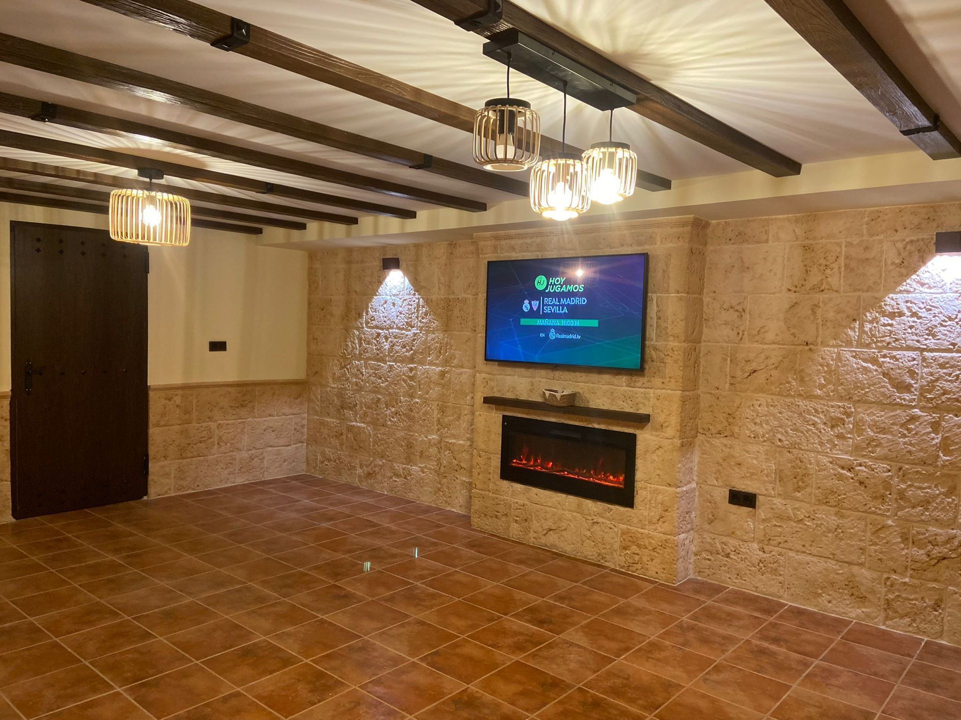 Una sala de estar con chimenea y un televisor de pantalla plana en la pared.