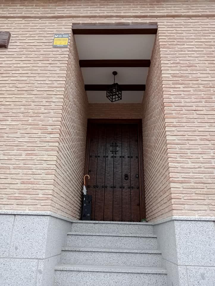 Un edificio de ladrillo con una puerta de madera y escaleras.