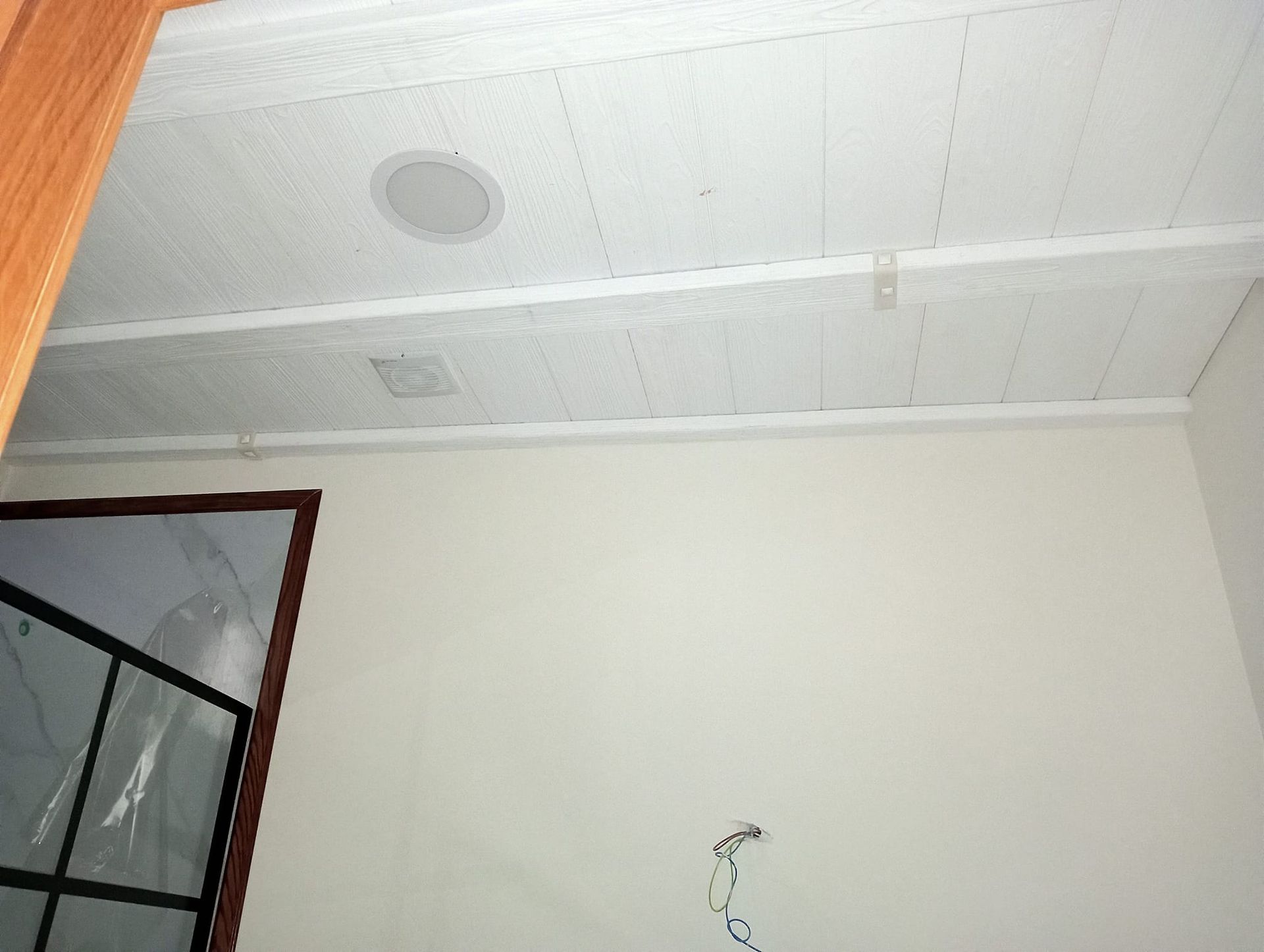 Una habitación con un techo blanco y una ventana