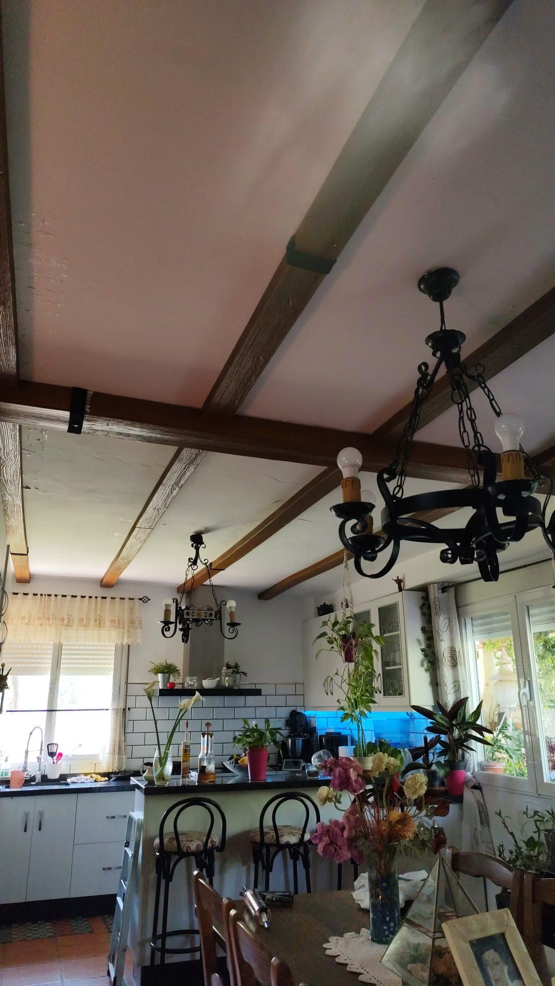 Una cocina con una mesa y sillas y una lámpara de araña colgando del techo.