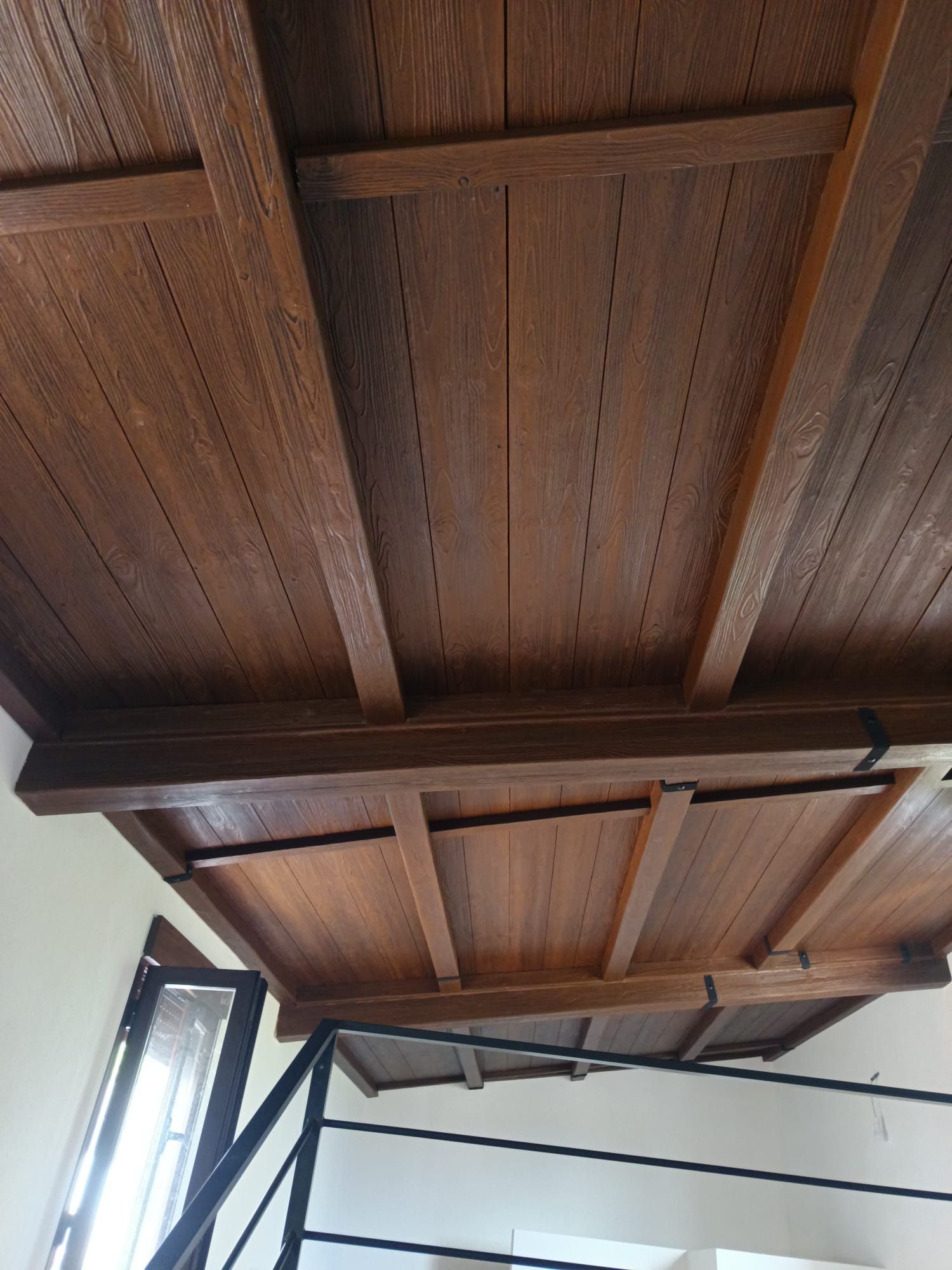 Un techo de madera con una escalera al fondo.