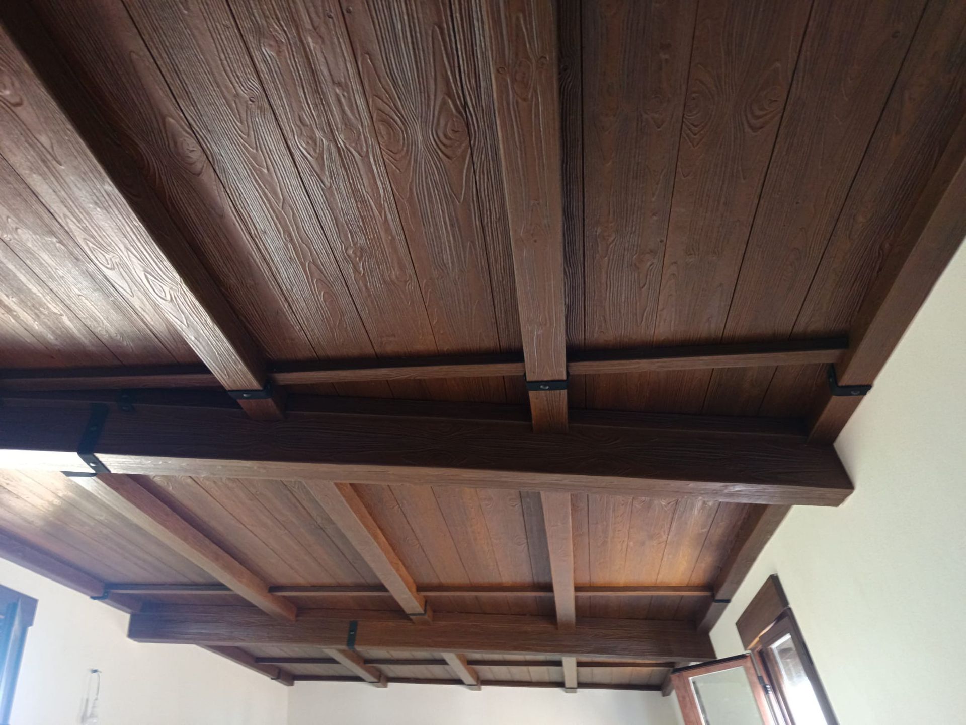 Un techo de madera en una habitación con ventana.