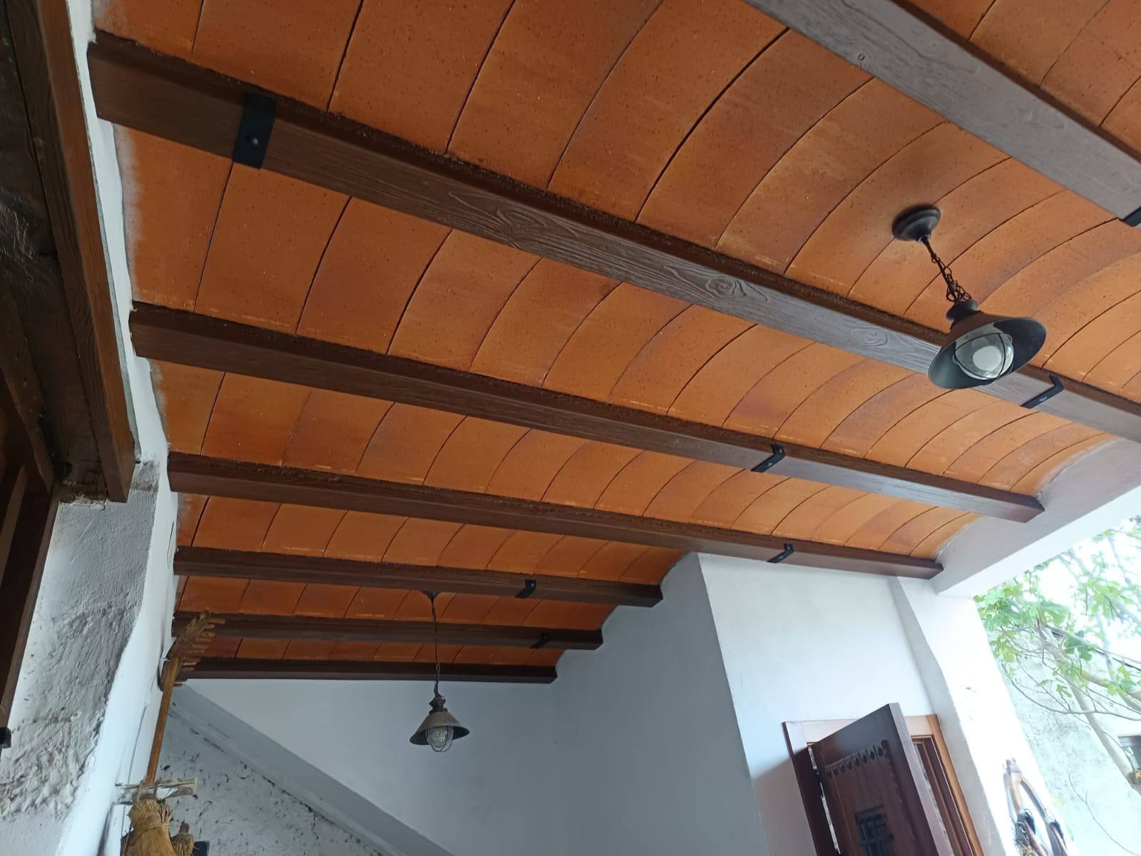 Un techo con vigas de madera y un ventilador de techo.