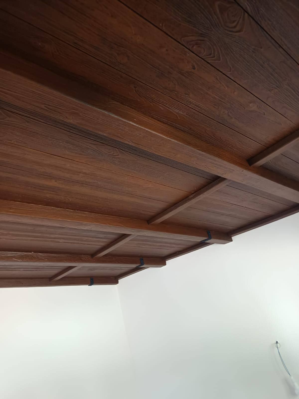 Un techo de madera en una habitación con paredes blancas.