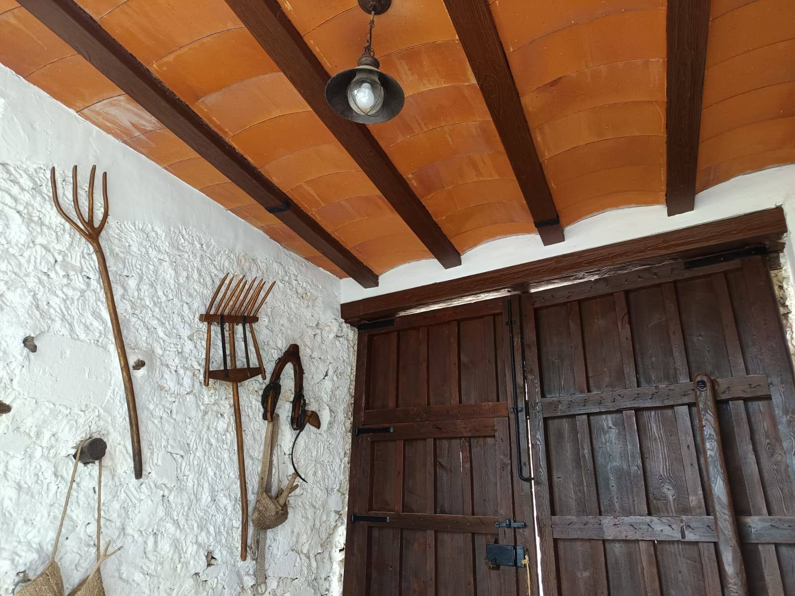 Un techo con vigas de madera y una lámpara colgando de él.