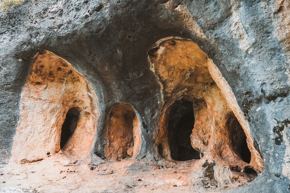 Tres formas erosionadas y ahuecadas en la superficie de una roca. La más grande está a la derecha; las demás son más pequeñas, todas marrones.