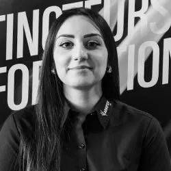 Portrait d'une femme en chemise noire, debout devant un fond typographique audacieux