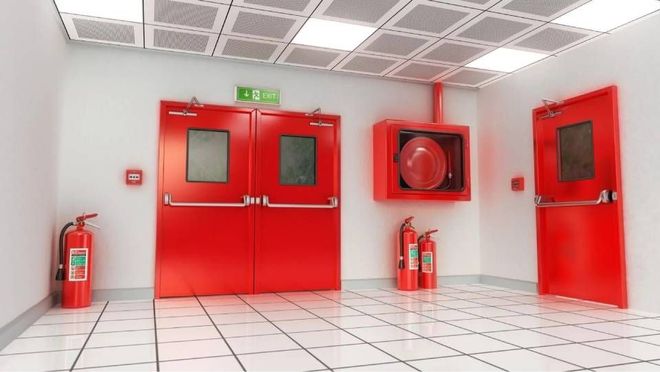 Portes de sortie de secours rouges dans un couloir blanc éclatant, avec extincteurs et dévidoir mural.