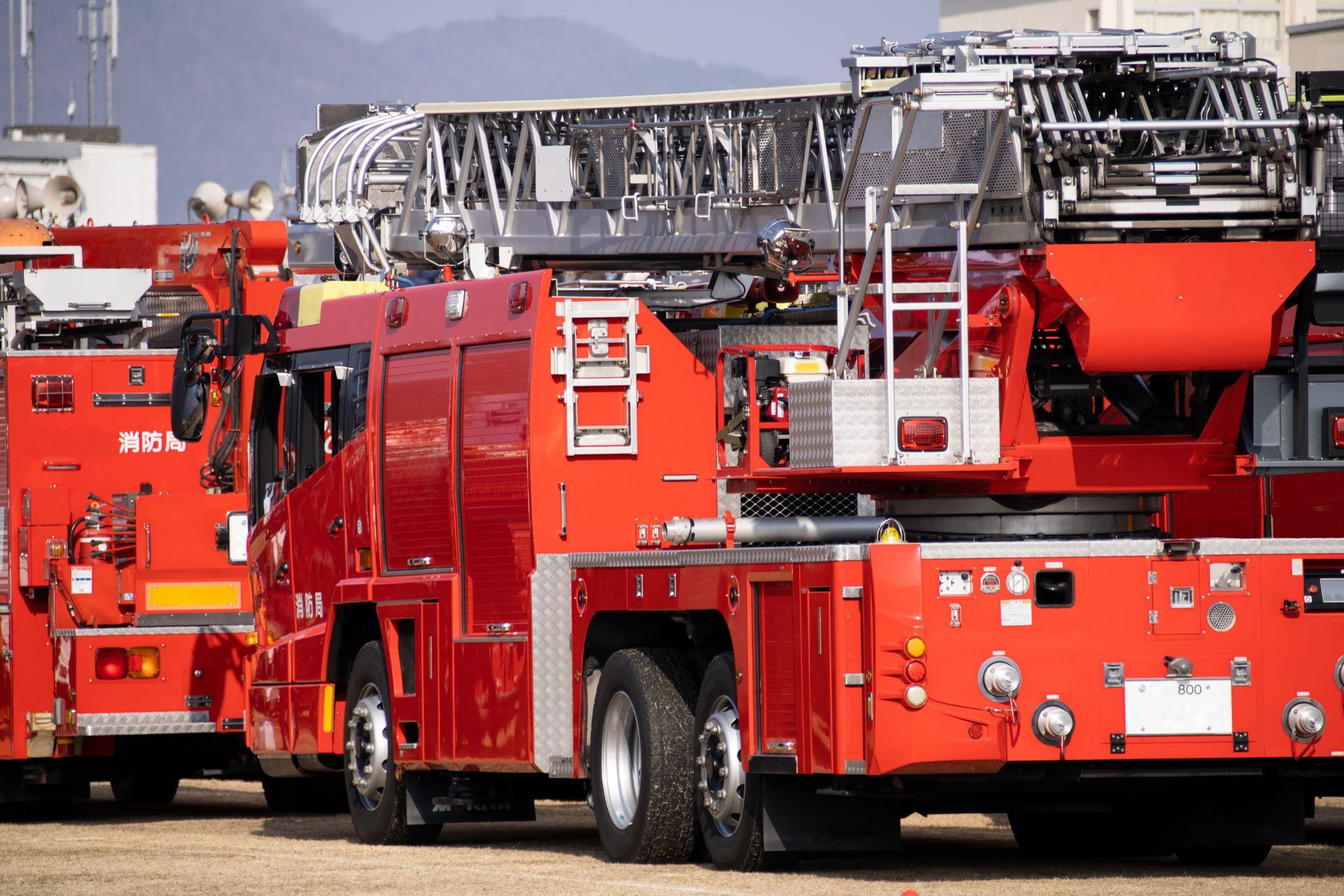 Camion de pompiers rouge avec une échelle garé à l'extérieur sur un terrain pavé