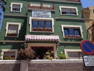 Un edificio verde con una señal de no estacionar enfrente.