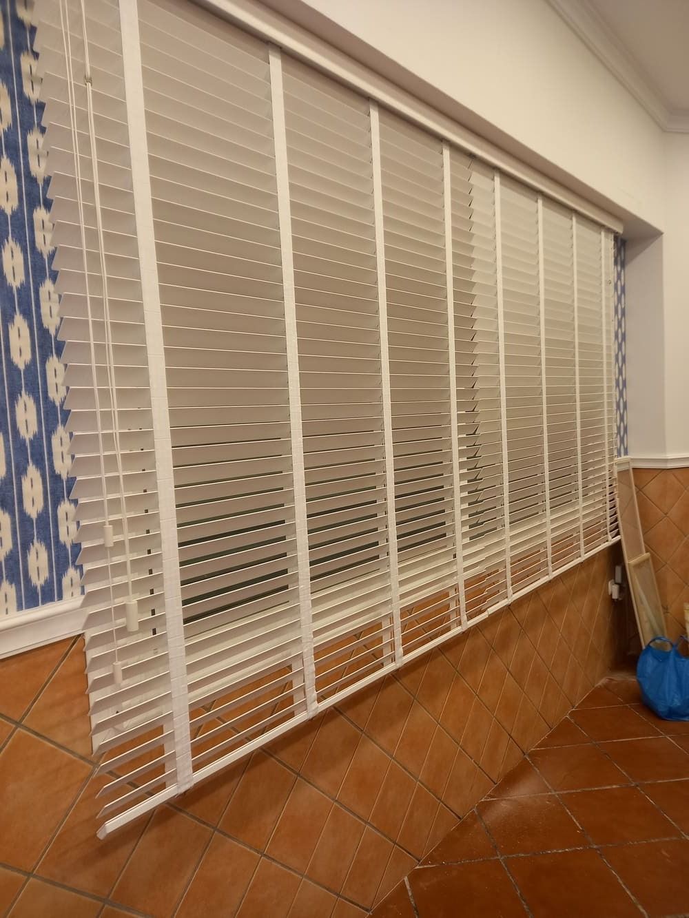 Una ventana grande con persianas en una habitación.