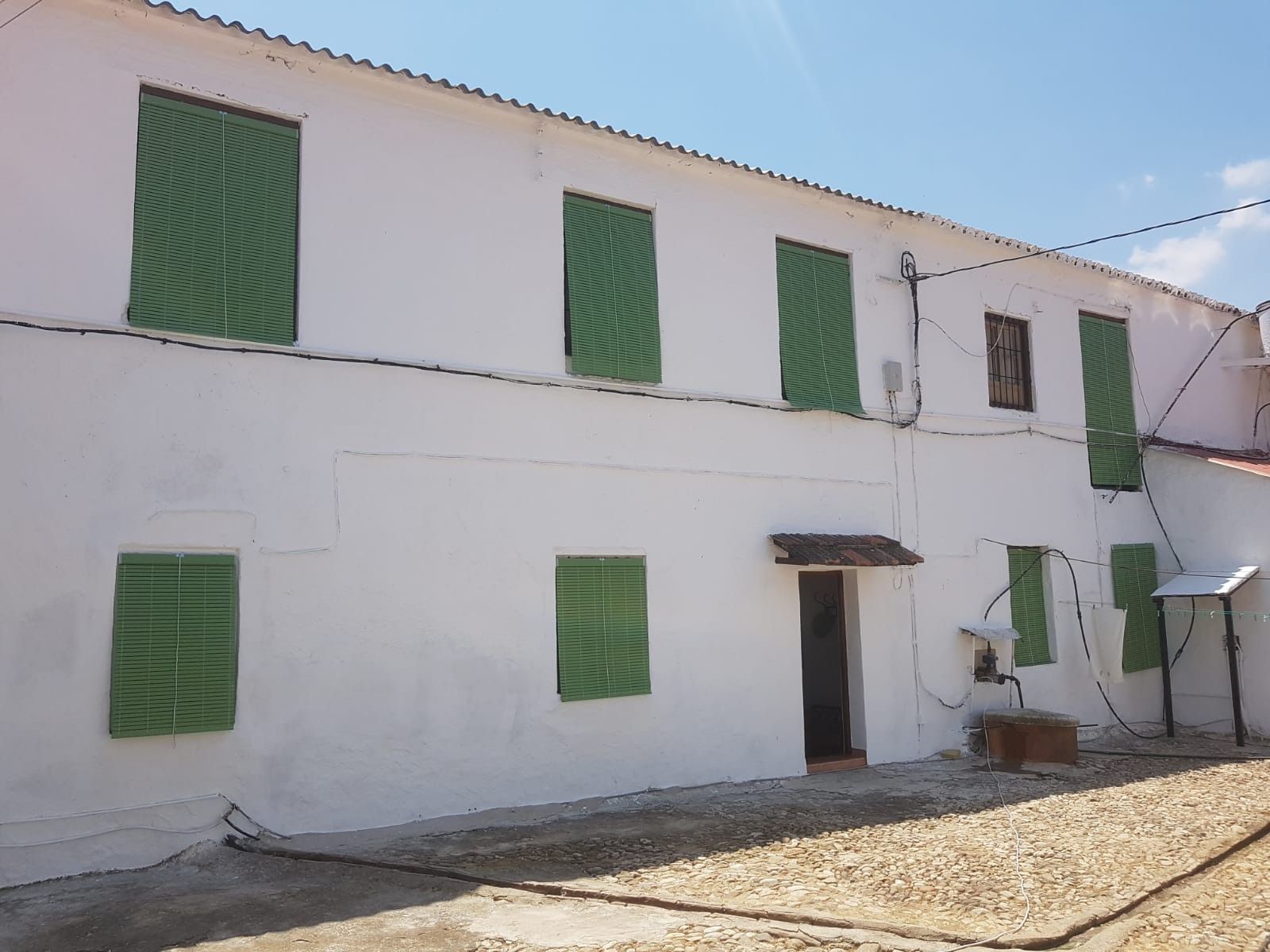 Un edificio blanco con persianas verdes en las ventanas