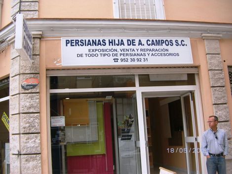 Un escaparate con un cartel que dice persianas hija de a. campos sc