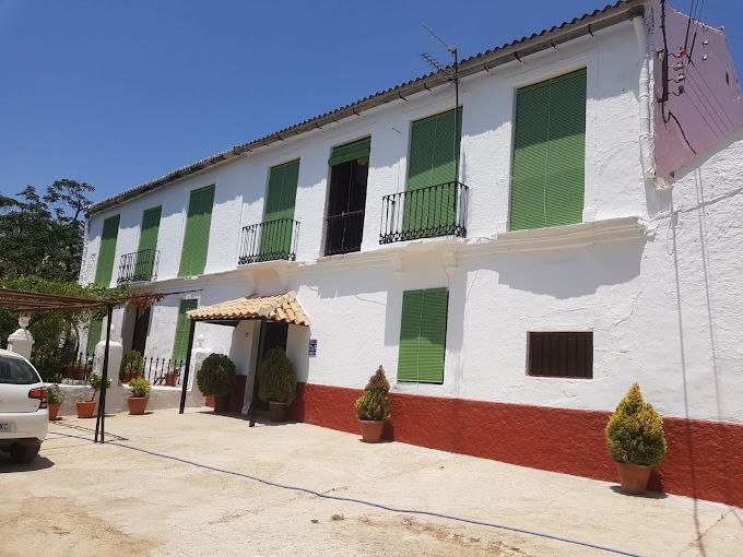 Un edificio blanco con persianas verdes en las ventanas