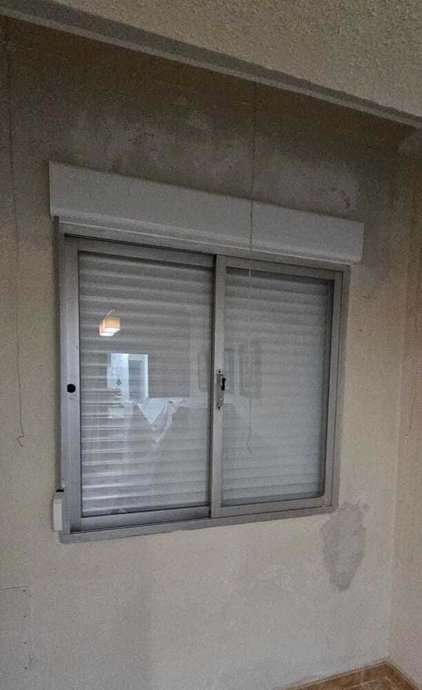 Una ventana con contraventanas está en una habitación.