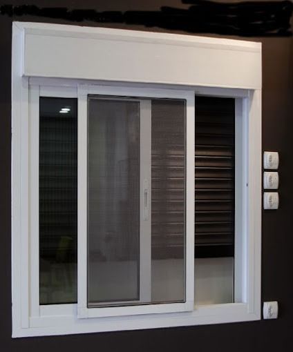 Una ventana blanca con una puerta corrediza con mosquitera