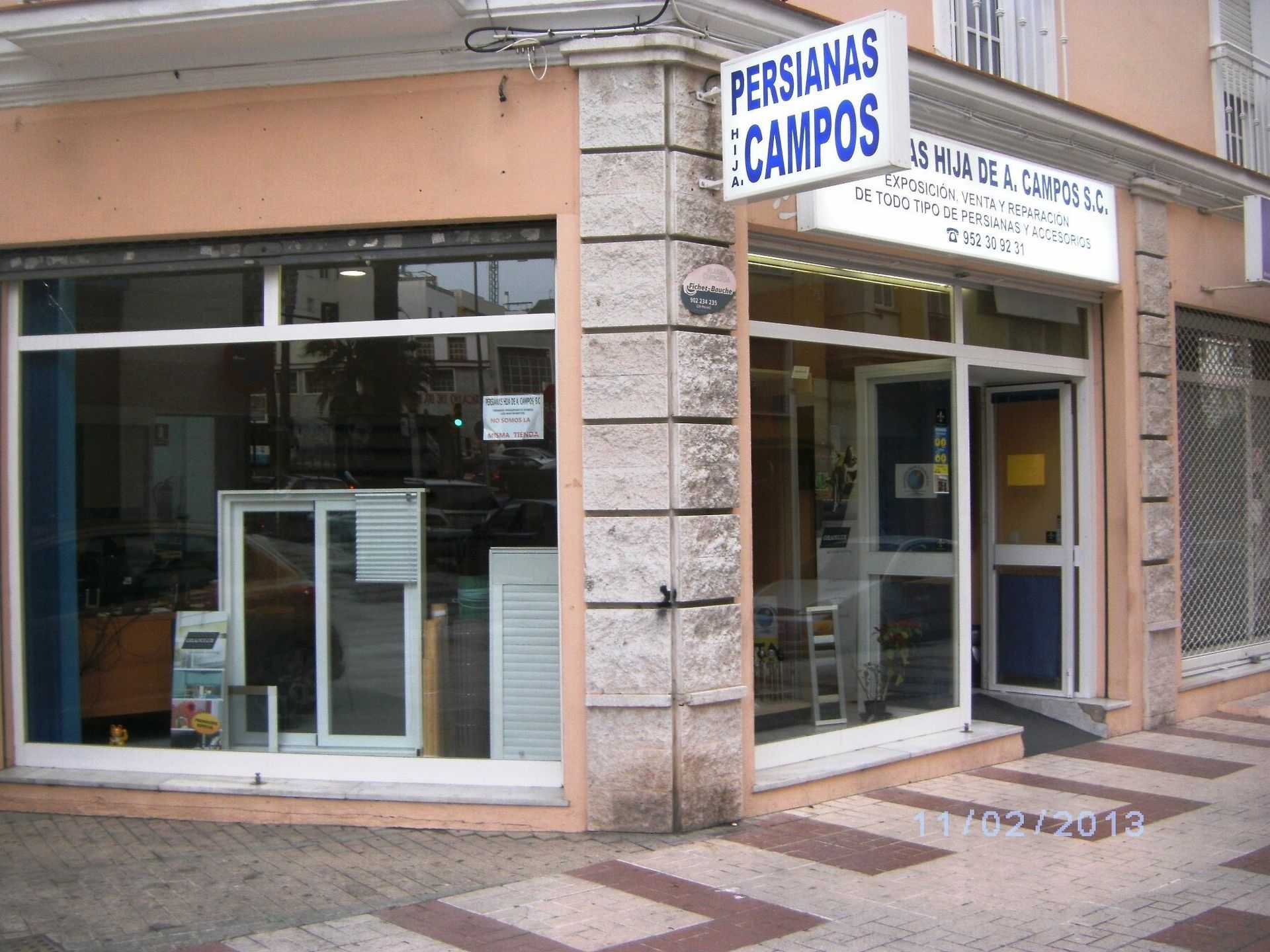 Un escaparate con un cartel que dice persianas campos