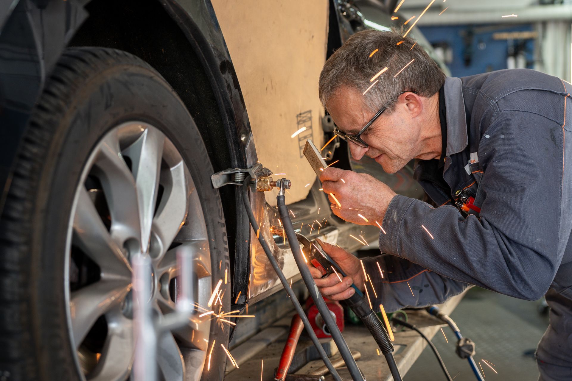 Ein Mann arbeitet in einer Garage an einem Auto.