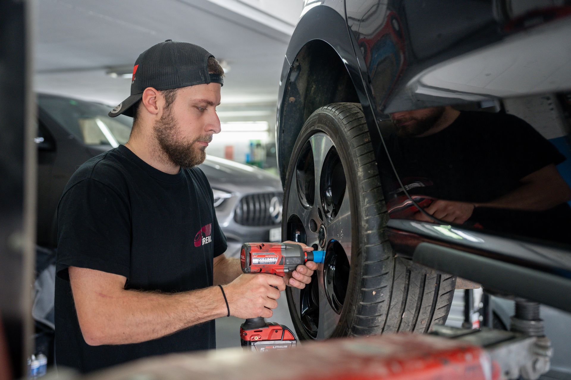 Ein Mann wechselt mit einem Schraubenschlüssel einen Autoreifen.