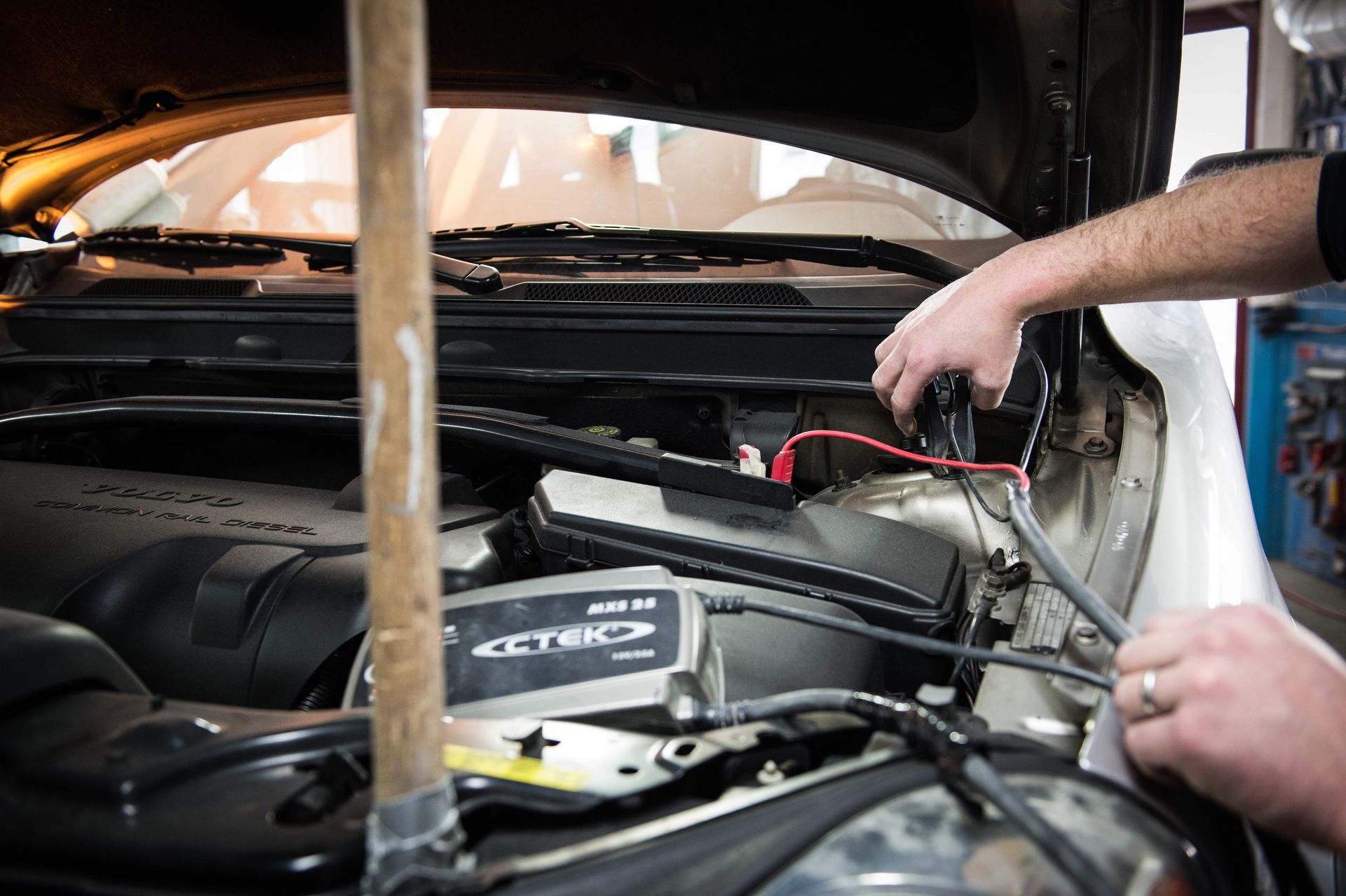 Ein Mann arbeitet am Motor eines Autos.
