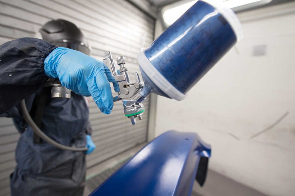 Nahaufnahme eine Autolackierpistole mit blauer Farbe