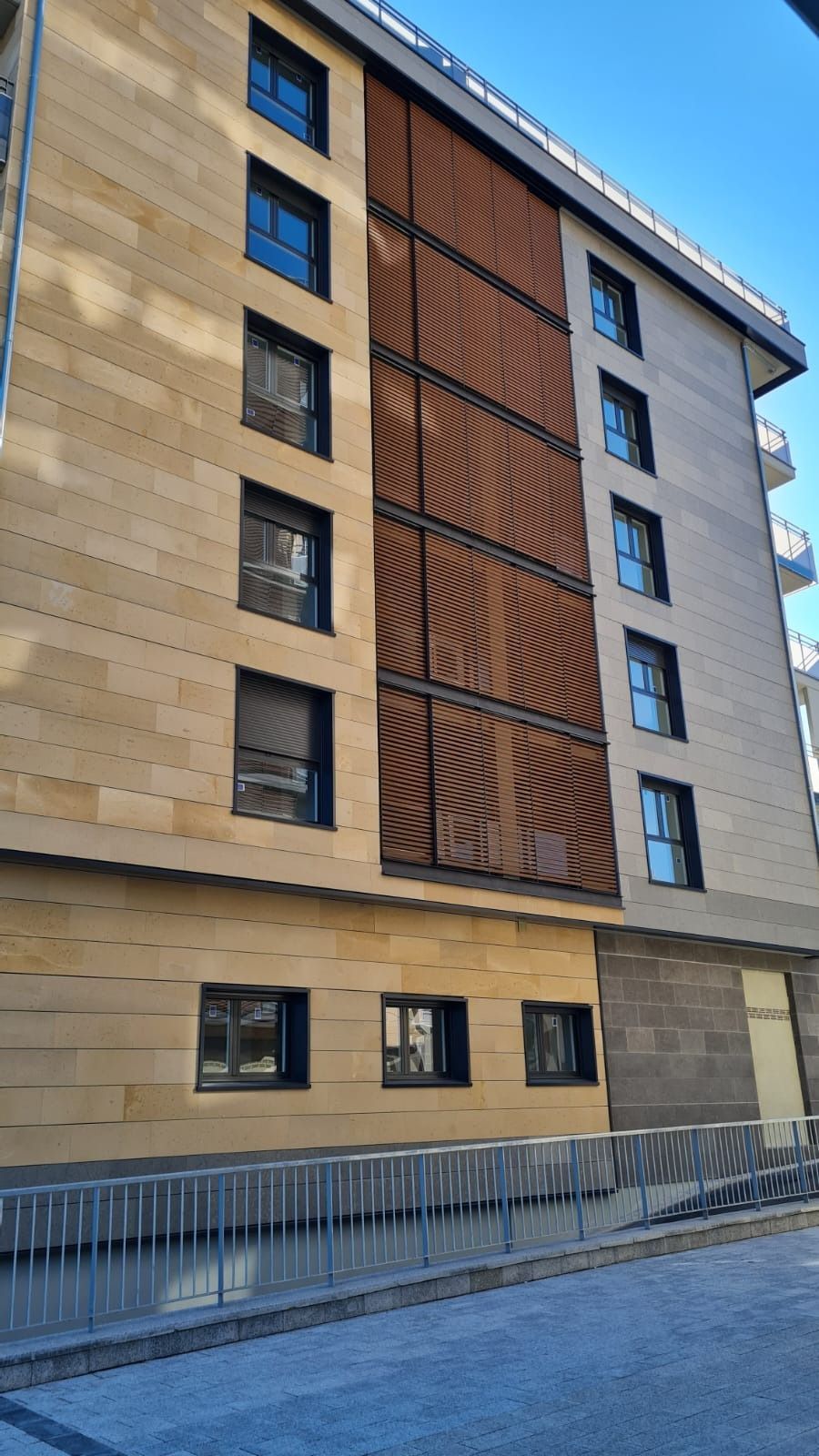 Un edificio grande con muchas ventanas y una valla delante.