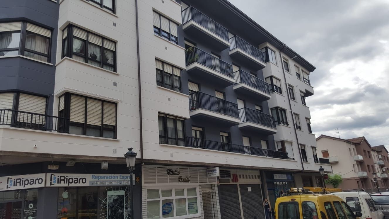 Un gran edificio con una camioneta amarilla estacionada enfrente.