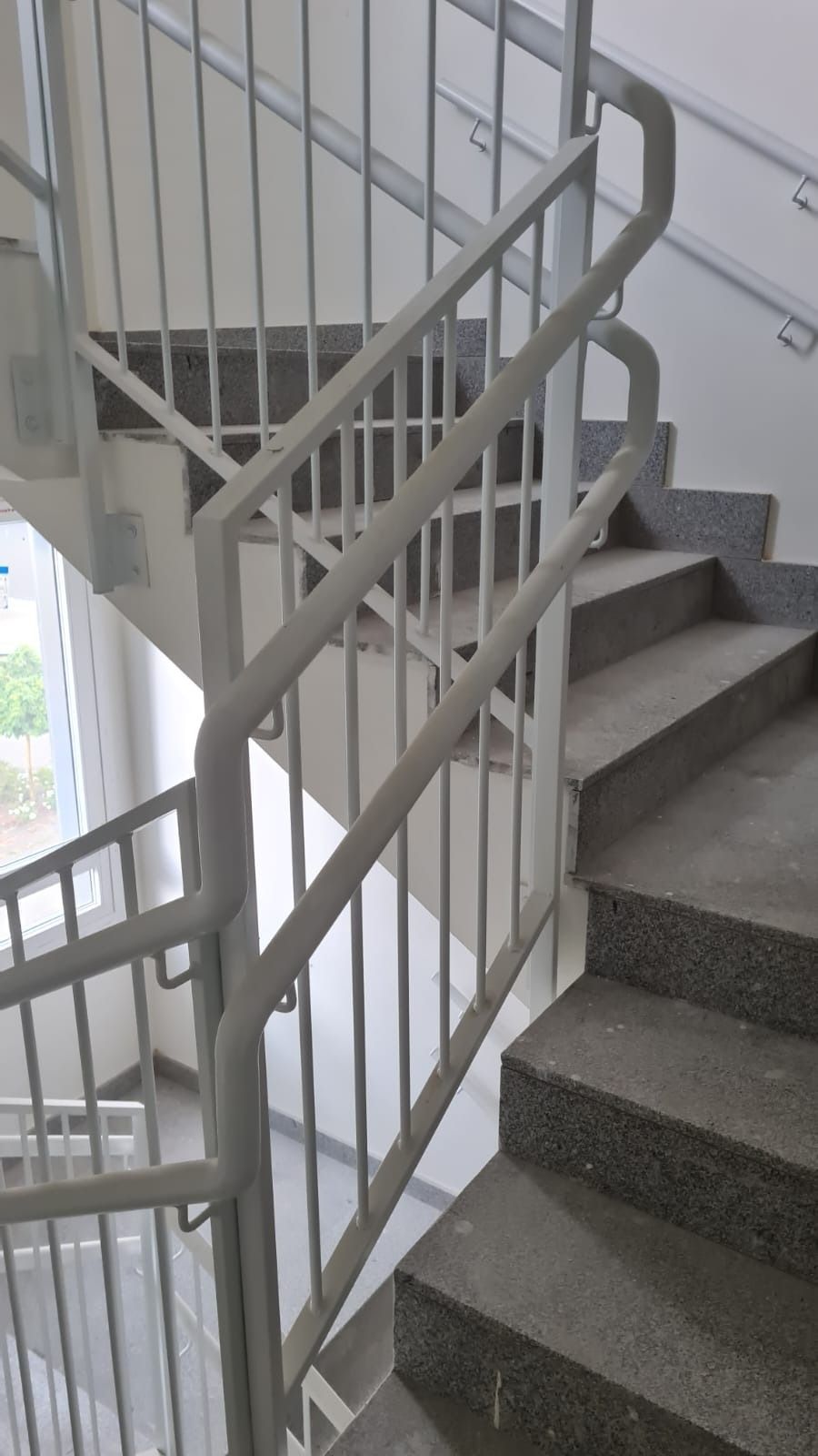 Una escalera con barandilla de metal y escalones en un edificio.