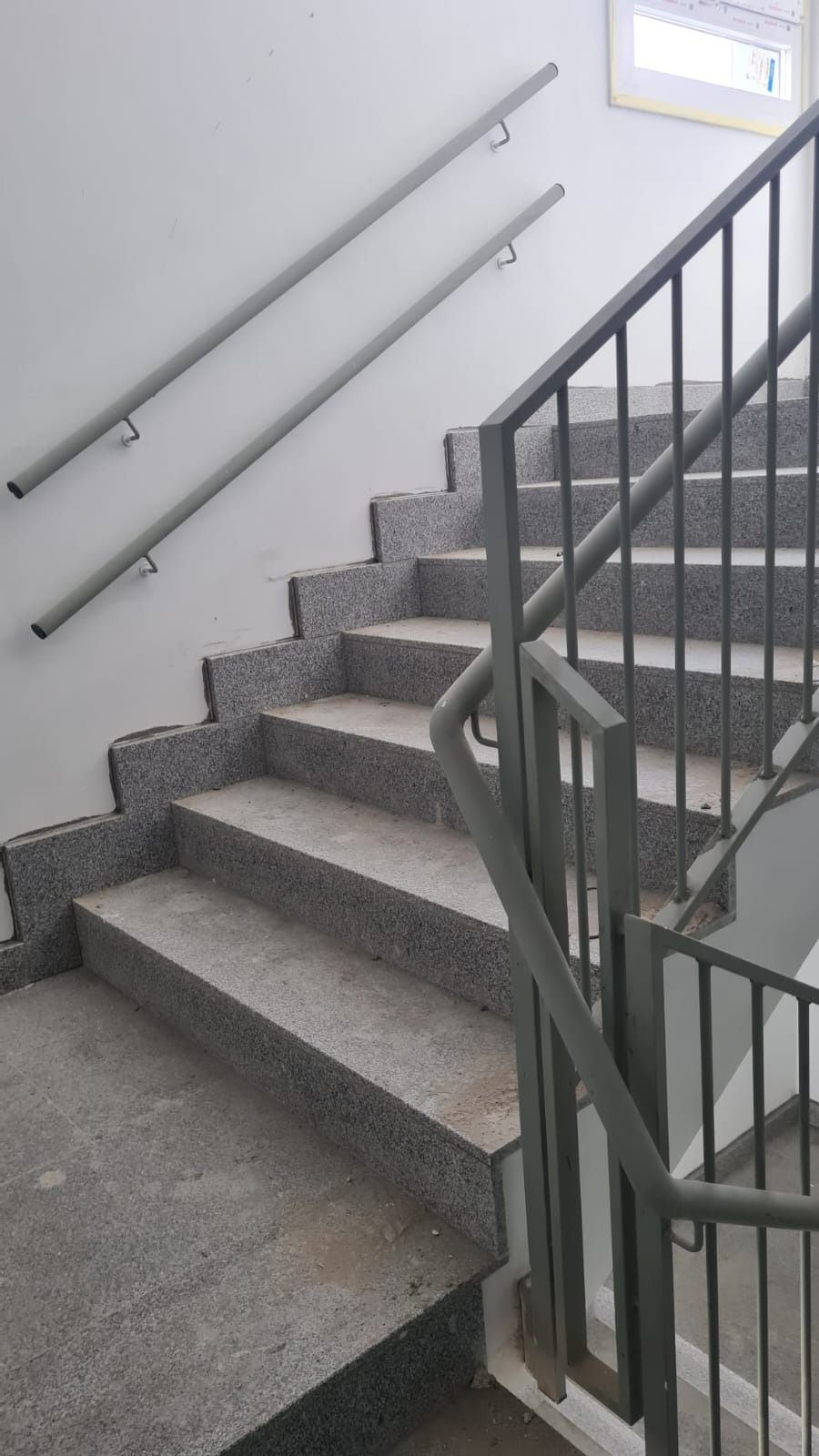 Un conjunto de escaleras con barandilla de metal en un edificio.
