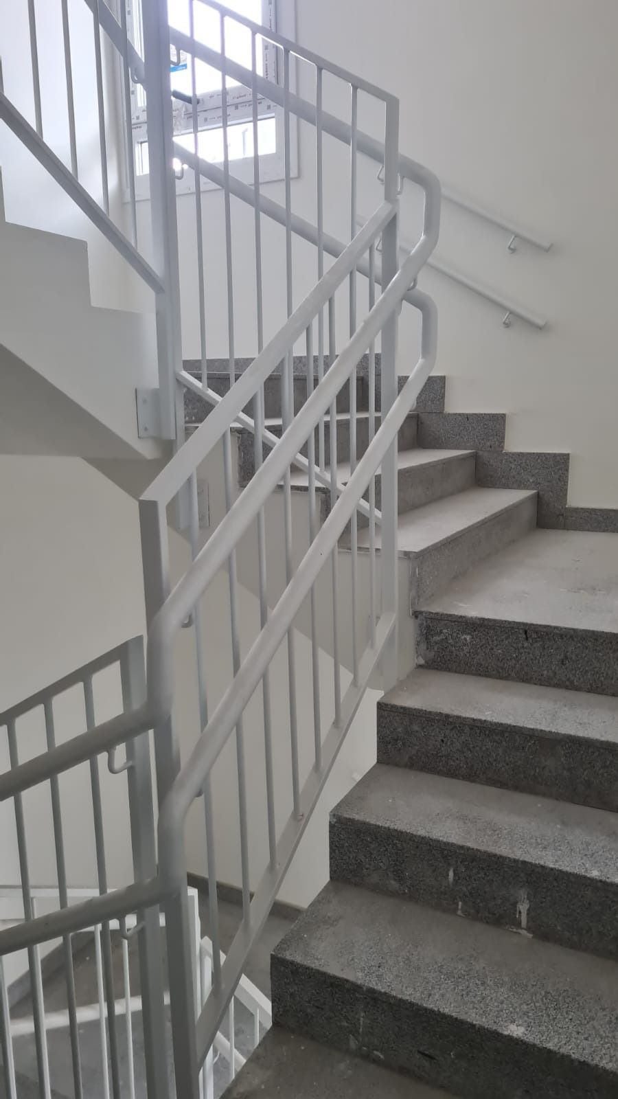 Una escalera con barandilla de metal en un edificio.