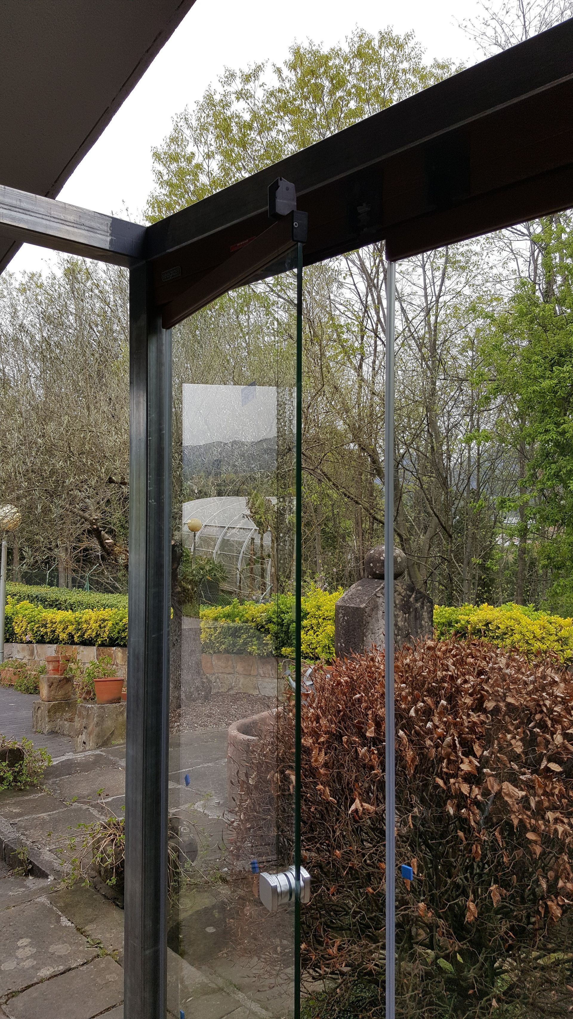 Una vista de un jardín a través de una puerta corrediza de vidrio.