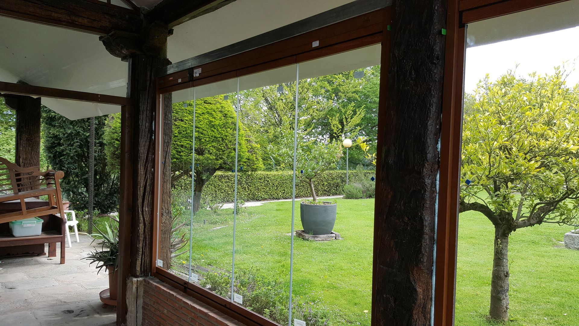 Una gran ventana con vista a un exuberante jardín verde.