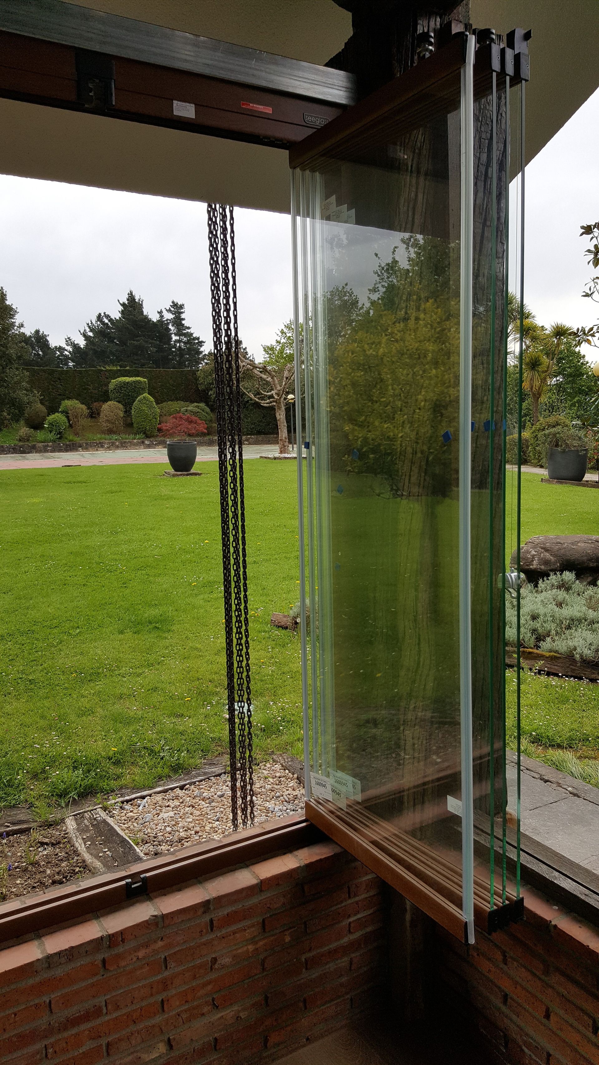 Una vista de un exuberante campo verde a través de una pared de vidrio.