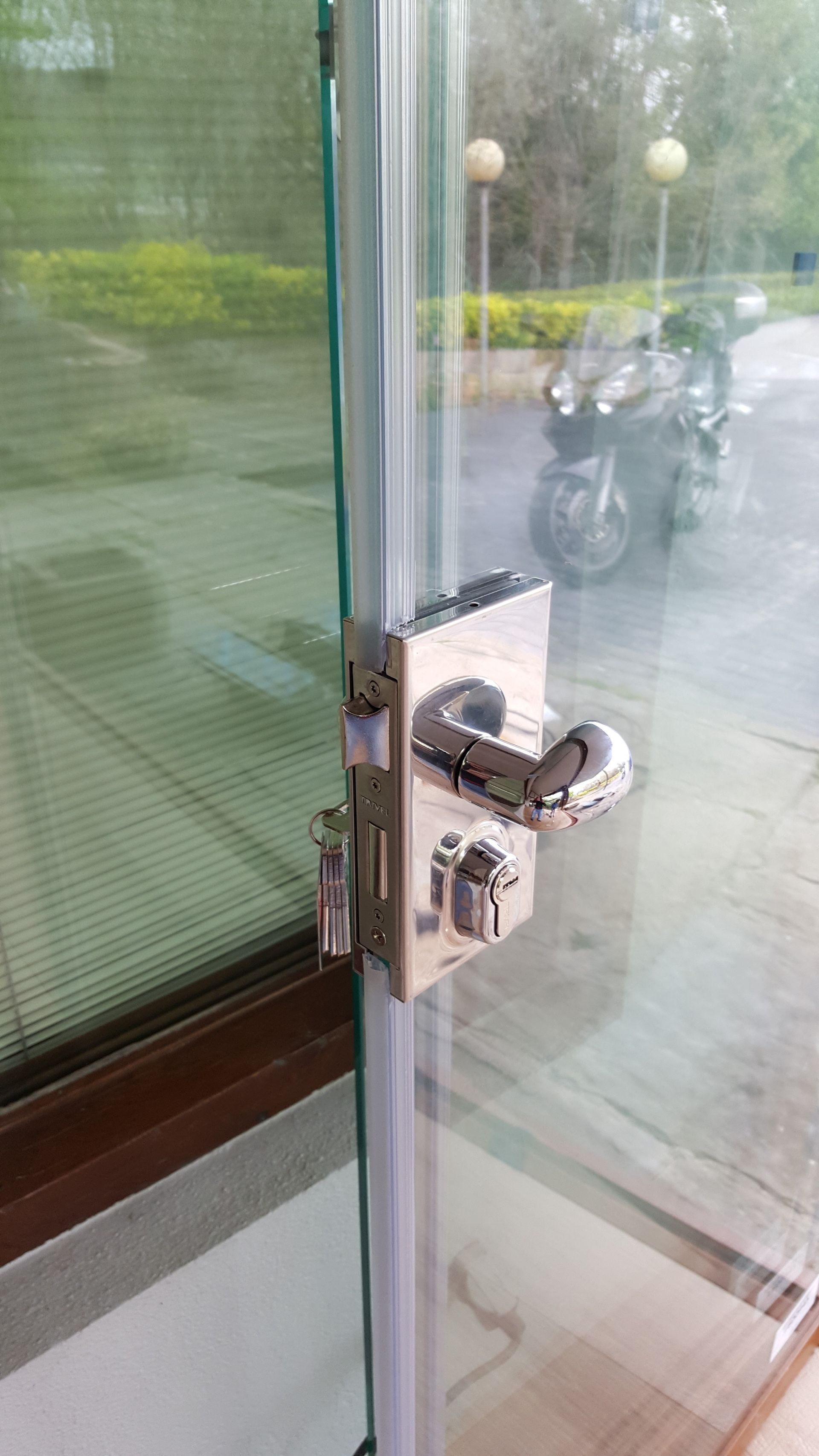 Un primer plano de una puerta de vidrio con cerradura.